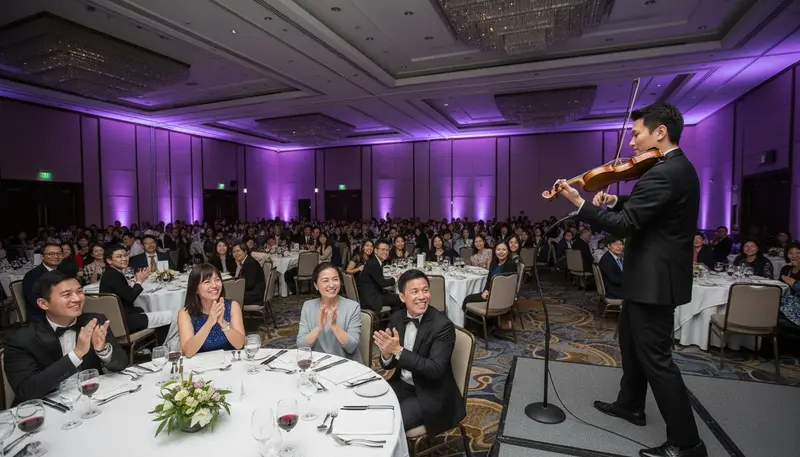 Violinist for a corporate event in Singapore playing on a low stage at a company dinner and dance in a hotel ballroom